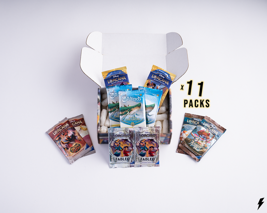 Open Booster Crate box containing 11 Disney Lorcana booster packs from various sets, shown with smaller side piles and “x 11 Packs” text on the right