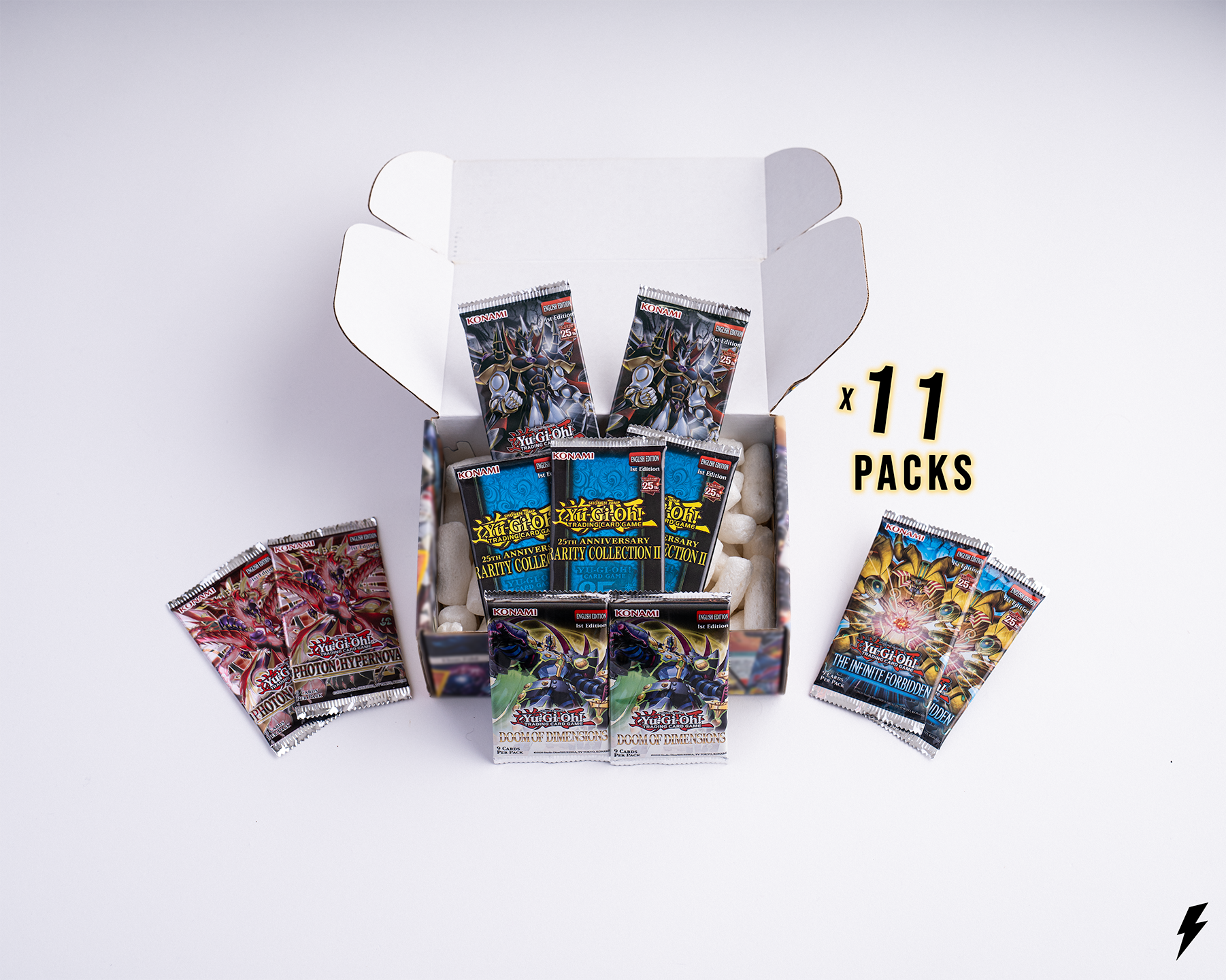 Open Booster Crate box containing 11 Yu-Gi-Oh! booster packs from various sets, shown with two smaller side piles and “x 11 Packs” text on the right.